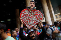 A supporter holds a heart-shaped sign with a figure of Venezuela's re-elected President Nicolas Maduro outside the National Electoral Council (CNE), in Caracas, Venezuela May 22, 2018. REUTERS/Carlos Garcia Rawlins