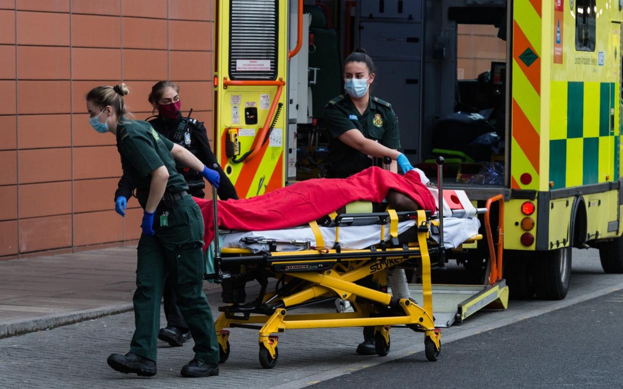 Paramedics transport a patient from the ambulance to the emergency department at the the Royal London Hospital - Barcroft Media 