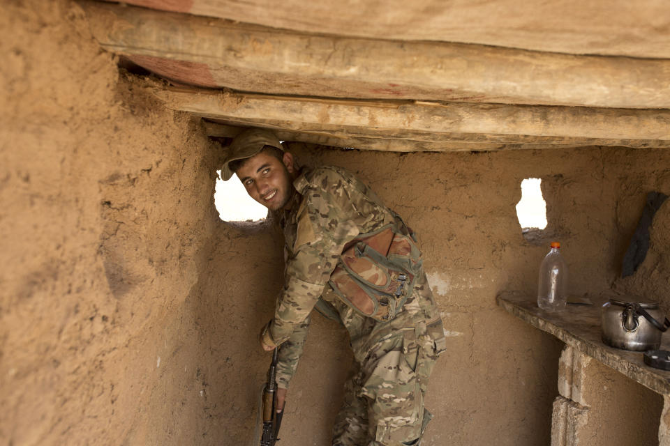 A soldier with the Tal Abyad Military Council, affiliated with the U.S.-backed Syrian Democratic Forces, stands in his post in the safe zone between Syria and the Turkish border near Tal Abyad, Syria, Friday, Sept. 6, 2019. (AP Photo/Maya Alleruzzo)