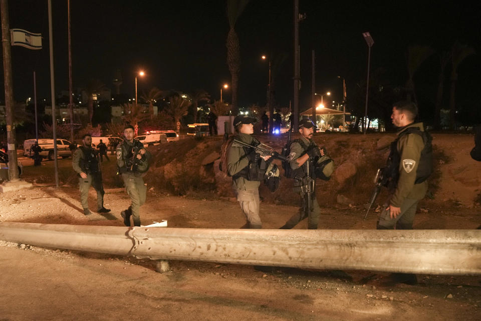 Israeli border police officers patrol next to the scene of a shooting attack outside the Israeli settlement of Maale Adumim, in the West Bank, Wednesday, Oct. 19, 2022. Israeli police say security guards shot dead a Palestinian attacker after he opened fire at them east of Jerusalem. (AP Photo/Mahmoud Illean)