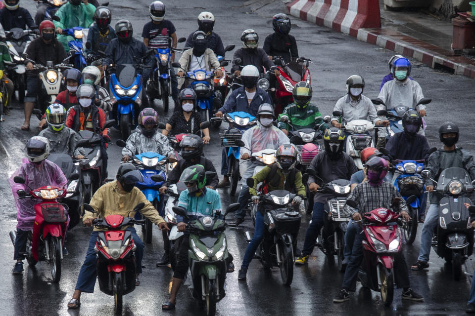 Motorcycles wearing face masks to help curb the spread of the new coronavirus wait at a stoplight in Bangkok, Thailand, Tuesday, May 26, 2020. (AP Photo/Sakchai Lalit)