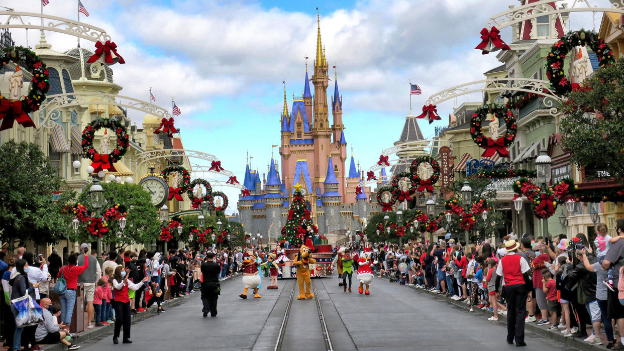 Crowds line Main Street USA, with Cinderella Castle on the horizon, at the Magic Kingdom at Walt Disney World.