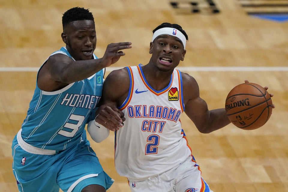 Oklahoma City Thunder guard Shai Gilgeous-Alexander drives around Charlotte Hornets guard Terry Rozier during the first half of an NBA basketball game in Charlotte, N.C., Saturday, Dec. 26, 2020. (AP Photo/Chris Carlson)