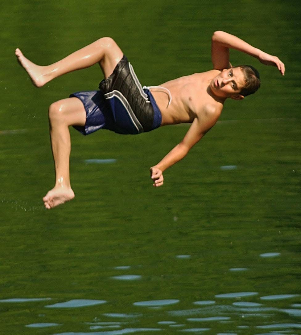 A swimmer flips off a diving board into the The Quarry which is a private swimming park in Peninsula located off Route 303 in this file photo.