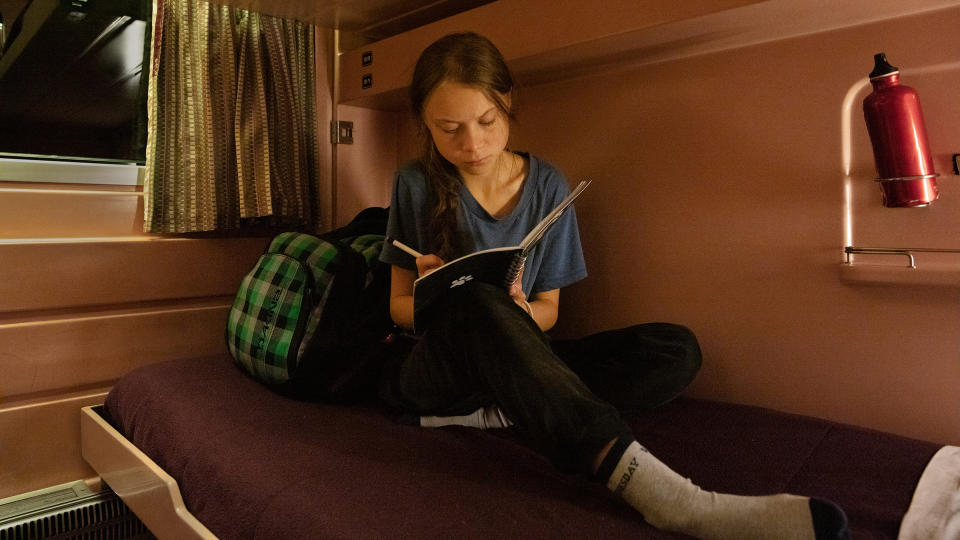 Greta Thunberg writes in her journal on the train as she travels from Lisbon to Madrid for a U.N. climate conference on Dec. 5, 2019.<span class="copyright">Evgenia Arbugaeva for TIME</span>