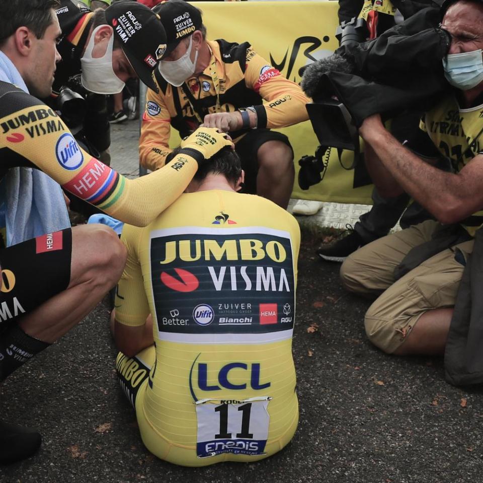 Primoz Roglic is comforted by teammates Tom Dumoulin, left, and Wout van Aert, second left, after losing the overall leader’s yellow jersey in stage 20.