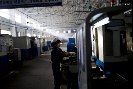 An employee works at a production line at a Wanxiang electric vehicle factory in Hangzhou, Zhejiang province, January 22, 2014. REUTERS/Aly Song