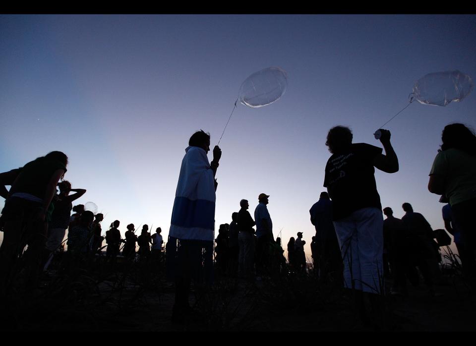 GRAND ISLE, LA - JULY 29:  Cacinda Voisin (C) holds a balloon to comemorate the eleven lives lost and 100 days of the BP oil spill on July 29, 2010 in Grand Isle, Louisiana.  Three to five million barrels of oil have spilled into the Gulf of Mexico since the BP Deepwater Horizon exploded on April 20, 2010.  (Photo by Chris Graythen/Getty Images)