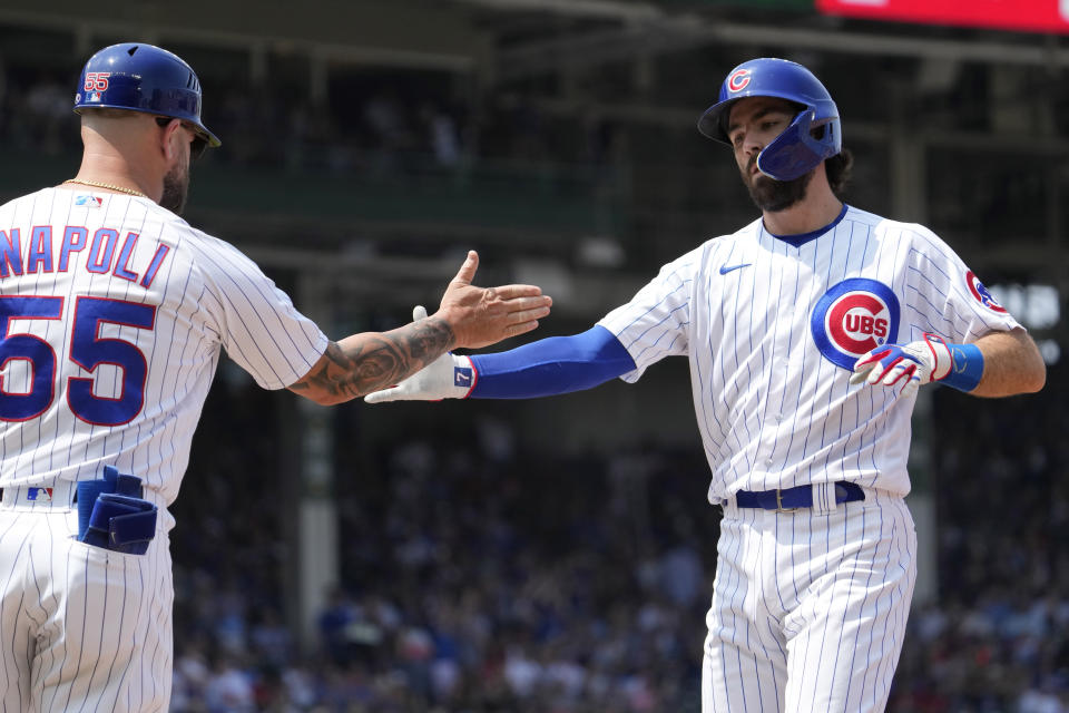 Chicago Cubs' Dansby Swanson, right, celebrates with first base coach Mike Napoli after hitting a one-run single during the third inning of a baseball game against the St. Louis Cardinals in Chicago, Sunday, July 23, 2023. (AP Photo/Nam Y. Huh)