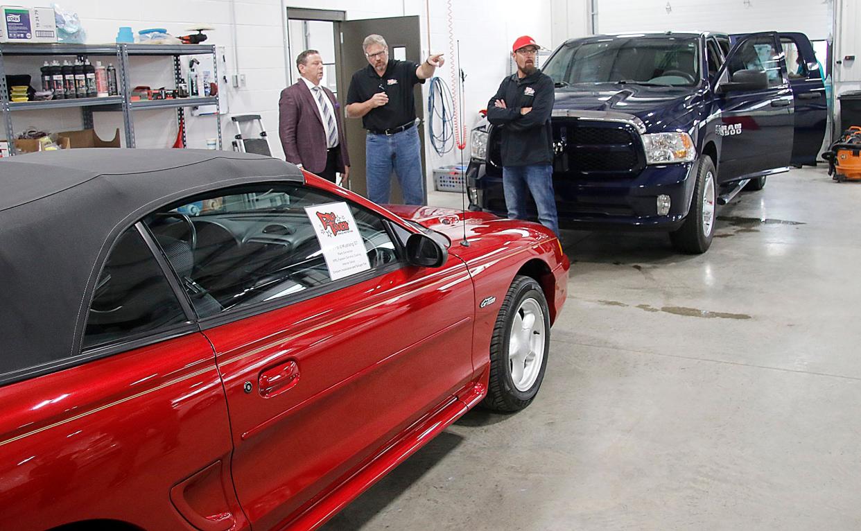 Dan Lawson, left, talks with Pro Touch's Dave Gisbon and Ryon Mays at the Pro Touch's open house for the new business on Thursday, May 5, 2022. TOM E. PUSKAR/TIMES-GAZETTE.COM