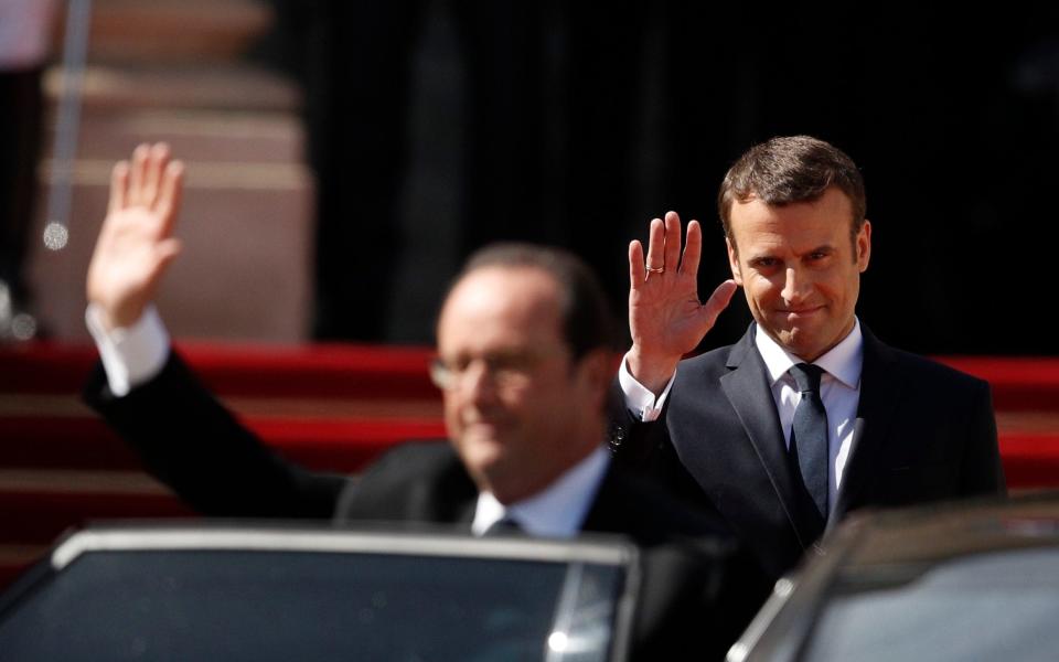 French President Emmanuel Macron, right, smiles as outgoing President Francois Hollande waves during Macron's inauguration ceremony in 2017 - POOL EPA