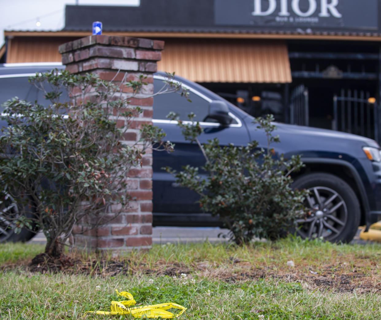 A small section of police tape remains on the scene where nine people were injured following an overnight shooting at the Dior Bar & Lounge in Baton Rouge, La., on Sunday, Jan. 22, 2023. (Michael Johnson/The Advocate via AP)