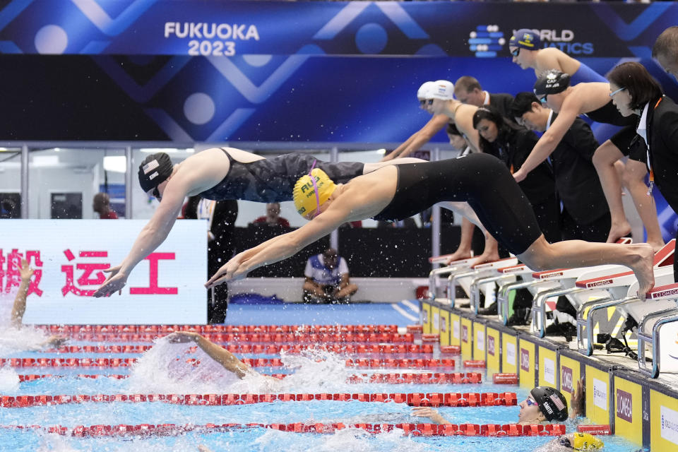 Abbey Harkin of Australia, front, and Lily King of the U.S., rear, dive as they compete during the women's 4x100m medley relay final at the World Swimming Championships in Fukuoka, Japan, Sunday, July 30, 2023. (AP Photo/Eugene Hoshiko)