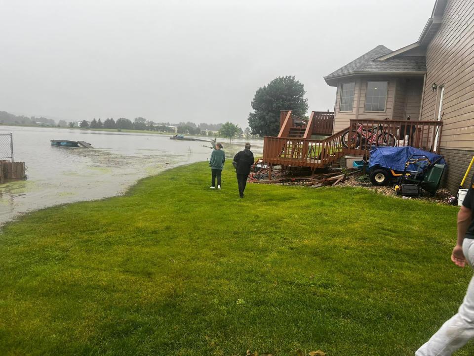 Canton residents look on as water from Christmas Lake in Canton rises near homes Thursday, June 20, 2024.