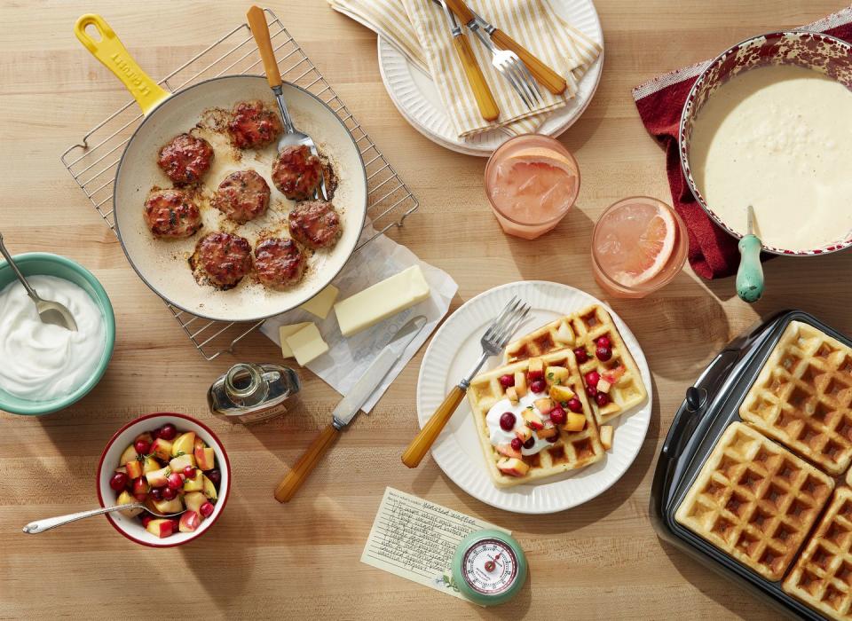 a table with sausage and waffles and grapefruit drinks