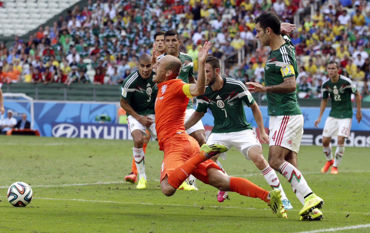 Netherlands&#39; Arjen Robben, center, goes down to win a penalty during the World Cup round of 16 soccer match between the Netherlands and Mexico at the Arena Castelao in Fortaleza, Brazil, Sunday, June 29, 2014. Netherlands won the match 2-1. (AP Photo/Wong Maye-E)