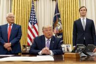 President Donald Trump, center, accompanied by U.S. Ambassador to Israel David Friedman, left, and Trump's White House senior adviser Jared Kushner, right, speaks in the Oval Office at the White House, Wednesday, Aug. 12, 2020, in Washington. Trump said on Thursday that the United Arab Emirates and Israel have agreed to establish full diplomatic ties as part of a deal to halt the annexation of occupied land sought by the Palestinians for their future state. (AP Photo/Andrew Harnik)