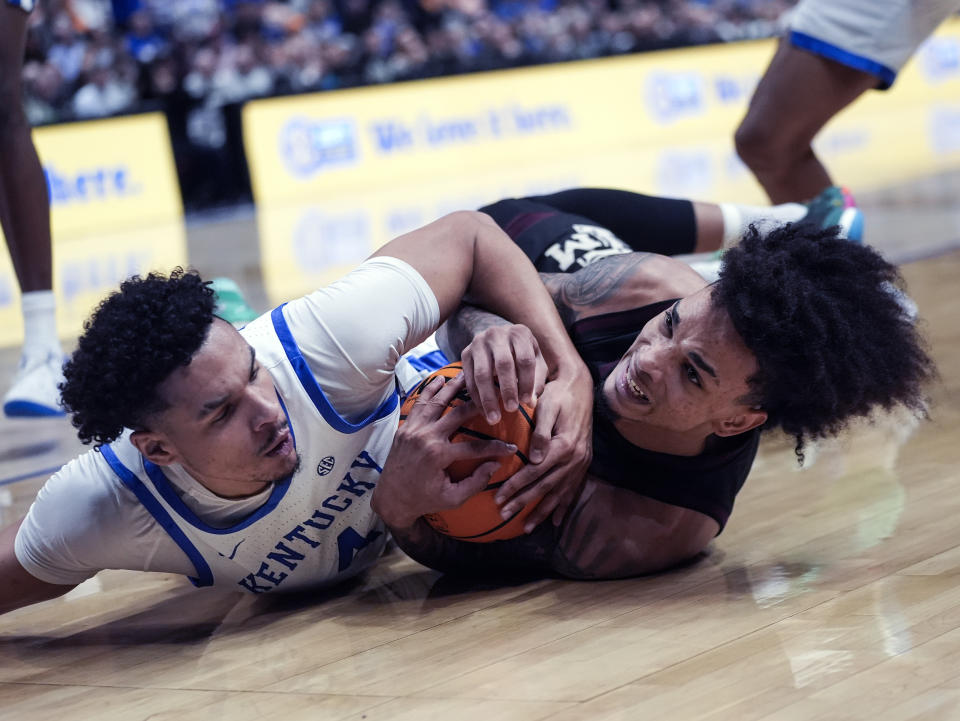 Kentucky forward Tre Mitchell (4) and Texas A&M forward Andersson Garcia (11) battle for a loose ball during the first half of an NCAA college basketball game at the Southeastern Conference tournament Friday, March 15, 2024, in Nashville, Tenn. (AP Photo/John Bazemore)