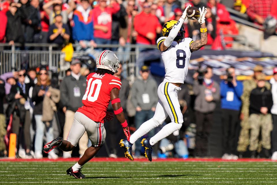 Michigan receiver Ronnie Bell catches a pass behind Ohio State cornerback Denzel Burke.