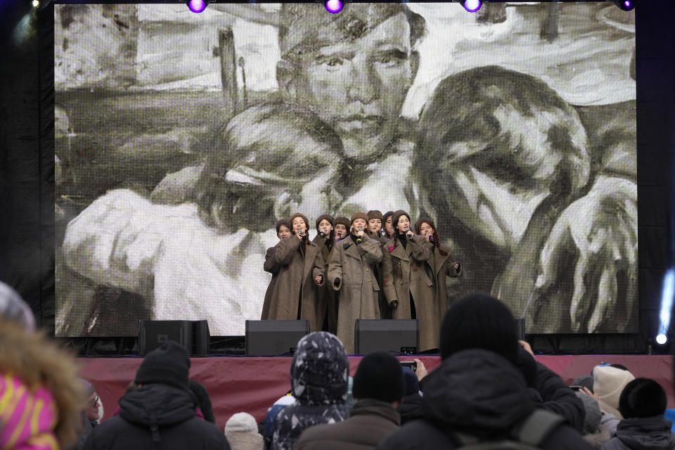 People listen to singers on a stage as they perform at a military-historical exhibition at the Dvortsovaya (Palace) Square, in St. Petersburg, Russia, Saturday, Jan. 27, 2024. The exhibition marked the 80th anniversary of the battle that lifted the Siege of Leningrad. The Nazi siege of Leningrad, now named St. Petersburg, was fully lifted by the Red Army on Jan. 27, 1944. More than 1 million people died mainly from starvation during the nearly900-day siege. (AP Photo/Dmitri Lovetsky)