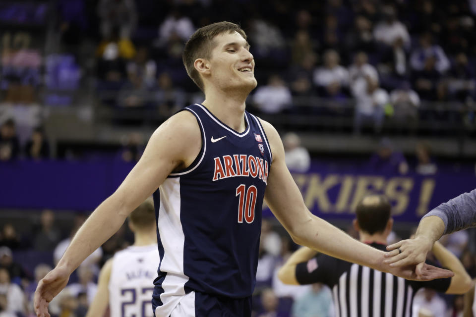 Arizona forward Azuolas Tubelis smiles as he receives hand slaps while walking to the bench after drawing a foul against Washington during the second half of an NCAA college basketball game, Saturday, Jan. 28, 2023, in Seattle. (AP Photo/John Froschauer)