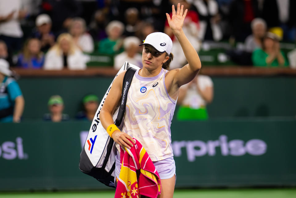 Iga Swiatek waves to the crowd at Indian Wells.