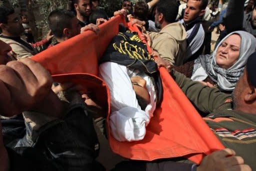 Palestinian mourners carry the body of 12-year-old schoolboy Ayoub Asalya, during his funeral in Jabalyia refugee camp in the northern Gaza Strip. New Israeli air strikes on the Gaza killed three Palestinians on Sunday, raising the death toll in a latest round of violence to 18, as militants fired over 120 rockets into Israel
