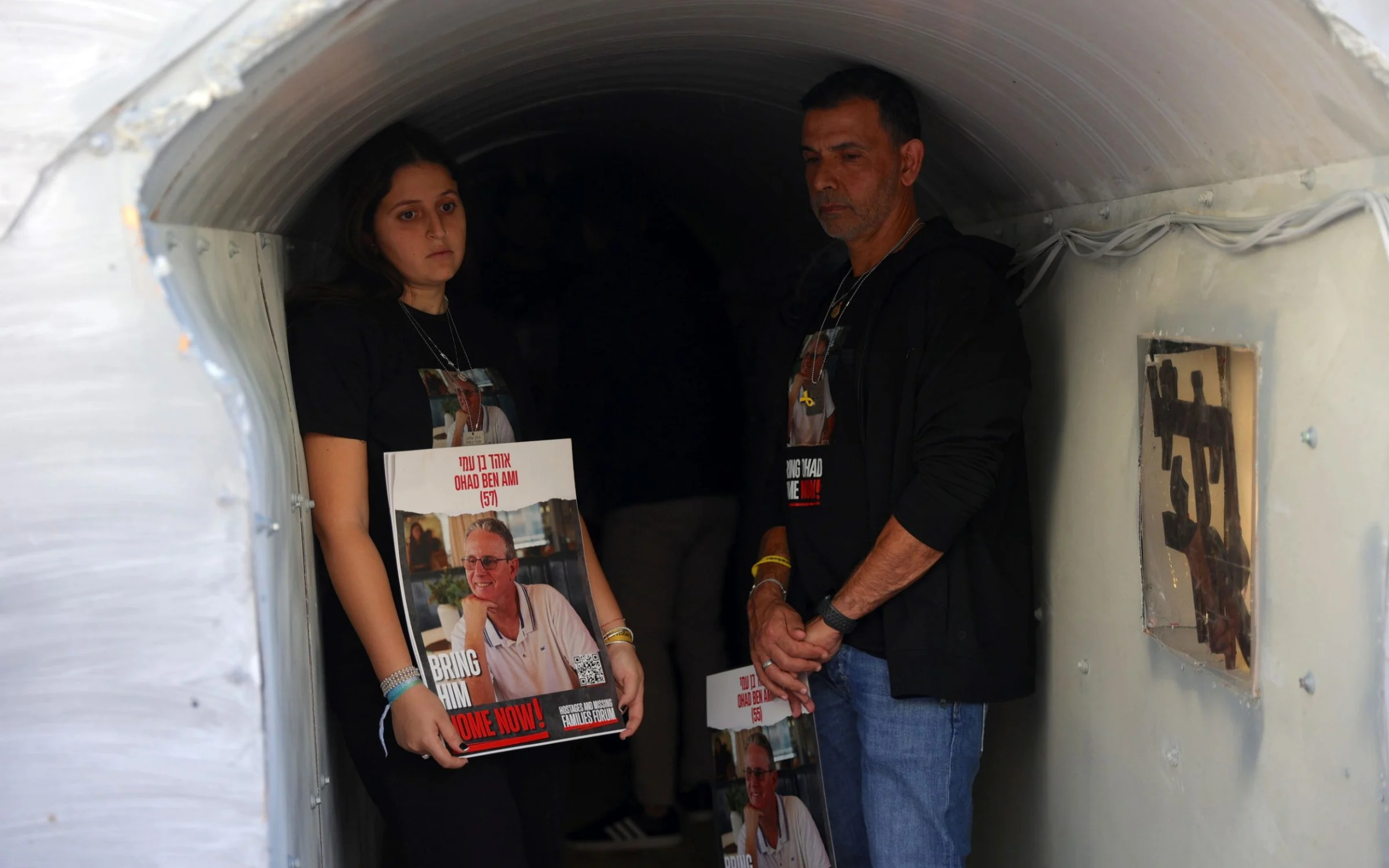 Family members of Ohad Ben Ami, who is still held as a hostage by Hamas in Gaza, hold his picture inside a 30-metre tunnel in Tel Aviv