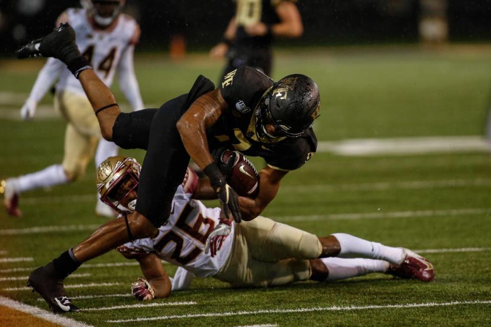 Wake Forest wide receiver Scotty Washington keeps his balance as he runs over Florida State defensive back Asante Samuel Jr. (26) after a catch in the second half of an NCAA college football game in Winston-Salem, N.C., Saturday, Oct. 19, 2019. Wake Forest won 22-20. (AP Photo/Nell Redmond)