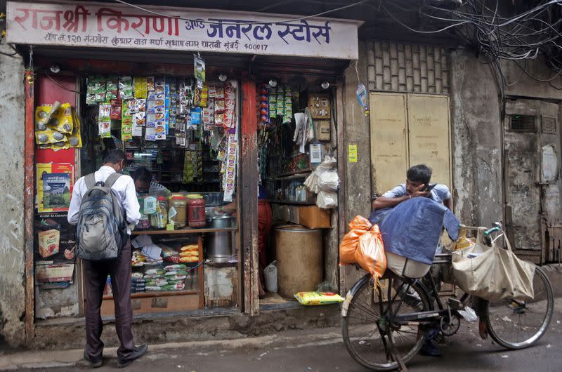 Shivkumar Singh speaks with a sales representative at his store in Dharavi , Mumbai