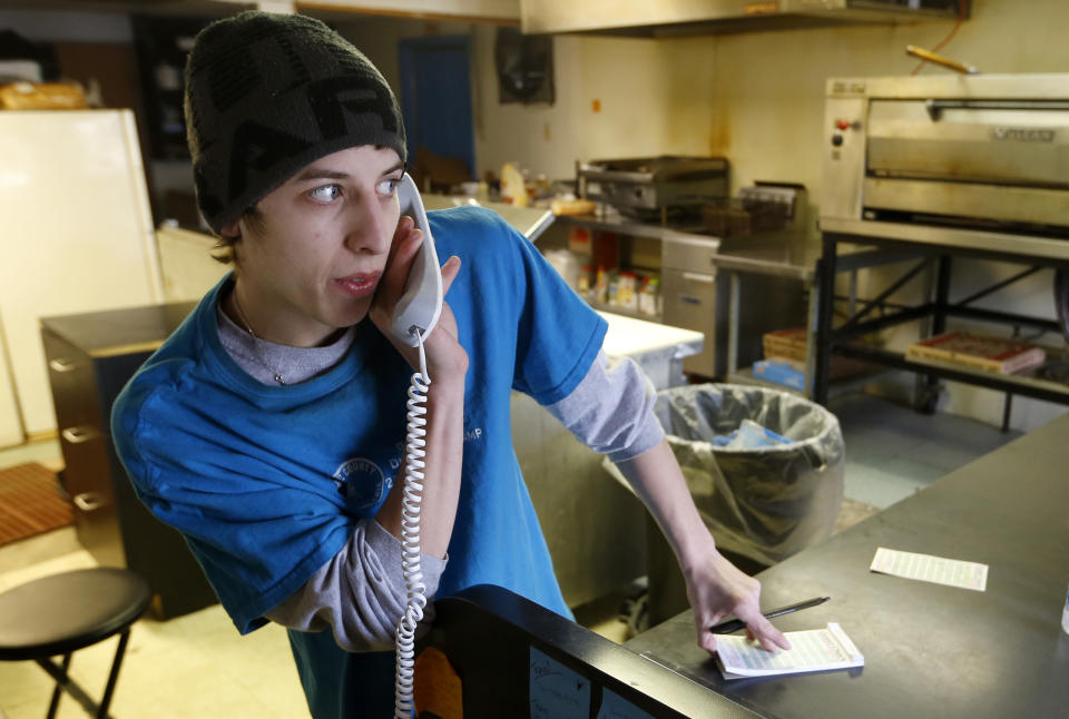 In this photo made on Saturday, March 1, 2014, Brian Scritchfield takes an order over the telephone at Bobtown Pizza in Bobtown, Pa. The little pizza shop in the southwestern corner of Pennsylvania was placed in the spotlight when energy giant Chevron offered coupons for free pizza from their shop to people who live near the area where a natural gas well that exploded, killing one worker on Feb 11, 2014. Some news stories and internet opinion posts have been critical about the offer by Chevron Corp., but many residents of the town said they didn’t mind the pizza offer. (AP Photo/Keith Srakocic)