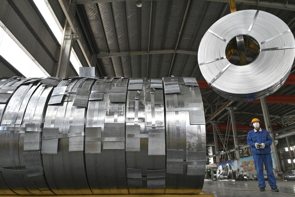 A worker uses machinery to move rolls fo metal at an equipment manufacturer in Handan in northern China's Hebei province on Feb. 28, 2022. China's ruling Communist Party is temporarily turning away from its longer-term ambitions to focus on pulling the economy out of a slump as the country heads into the annual meeting of its ceremonial legislature. (Chinatopix via AP)