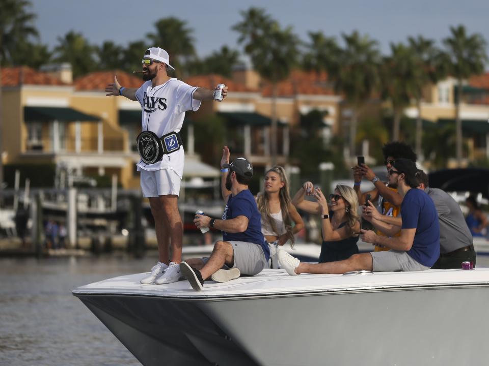 Tampa Bay Lightning's Alex Killorn spreads his arms wide at the front of a boat during the NHL hockey Stanley Cup champions' boat parade, Wednesday, Sept. 30, 2020, in Tampa, Fla. (Dirk Shadd/Tampa Bay Times via AP)