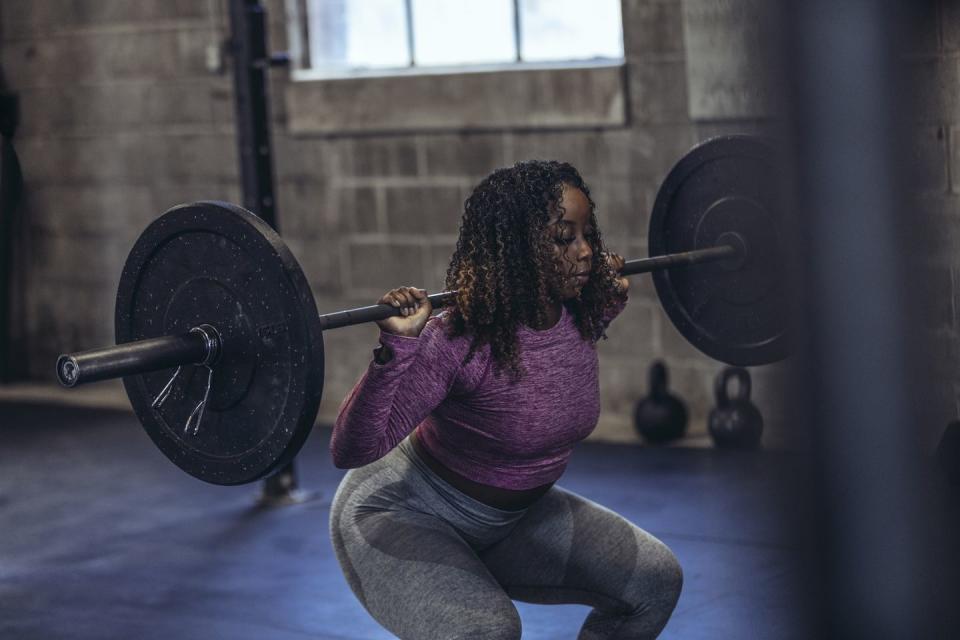 woman lifting barbell in gym