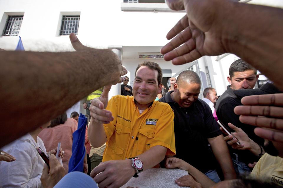 FILE - In this Dec. 9, 2015 file photo, reelected opposition congressman Tomas Guanipa greets supporters outside the National Electoral Council in Caracas, Venezuela. On Monday, Aug. 12, 2019, Venezuela’s supreme court stripped Guanipa and two other opposition lawmakers of immunity from prosecution as accused traitors amid rising political tension in the crisis-stricken nation. (AP Photo/Fernando Llano, File)