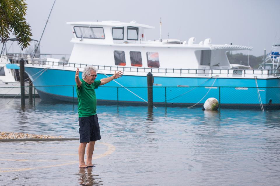 John Lundgren, a resident of upstate New York visiting family in Palm Beach County, poses for a picture in the flooding parking lot of the Lantana Public Boat Ramp ahead of the arrival of Tropical Storm Nicole to Palm Beach County on Wednesday, November 9, 2022, in Lantana, FL.