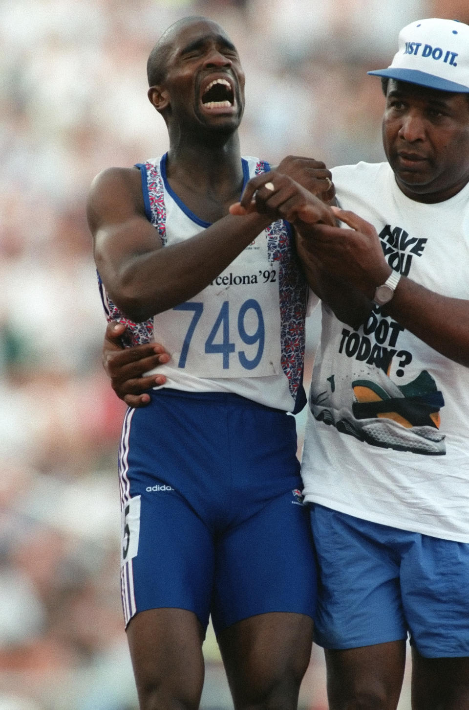 In this file photo taken on August 3, 1992 Derek Redmond (L) of Great Britain is helped by his father, Jim Redmond, in Barcelona after suffering an undetermined injury during a second round heat of the men's 400-meter run at the 1992 Summer Olympics.
