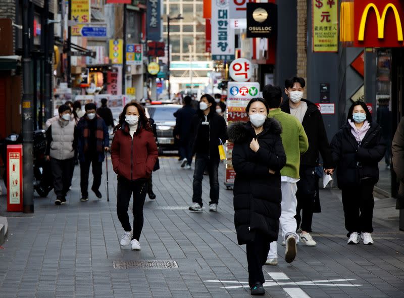 People wearing masks walk in a shopping district amid the coronavirus disease (COVID-19) pandemic in Seoul