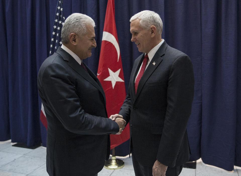 United States Vice President Mike Pence, right, and Turkey's Prime Minister Binali Yildirim, left, talk prior to their meeting during the Munich Security Conference in Munich, Germany, Saturday, Feb. 18, 2017. America's commitment to NATO is "unwavering," Pence said Saturday, reassuring allies about the direction the Trump administration might take but leaving open questions about where Washington saw its relationship with the European Union and other international organizations. (Prime Minister's Press Service, Pool Photo via AP)