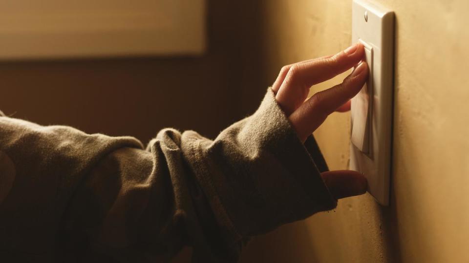 A girl operating a light switch