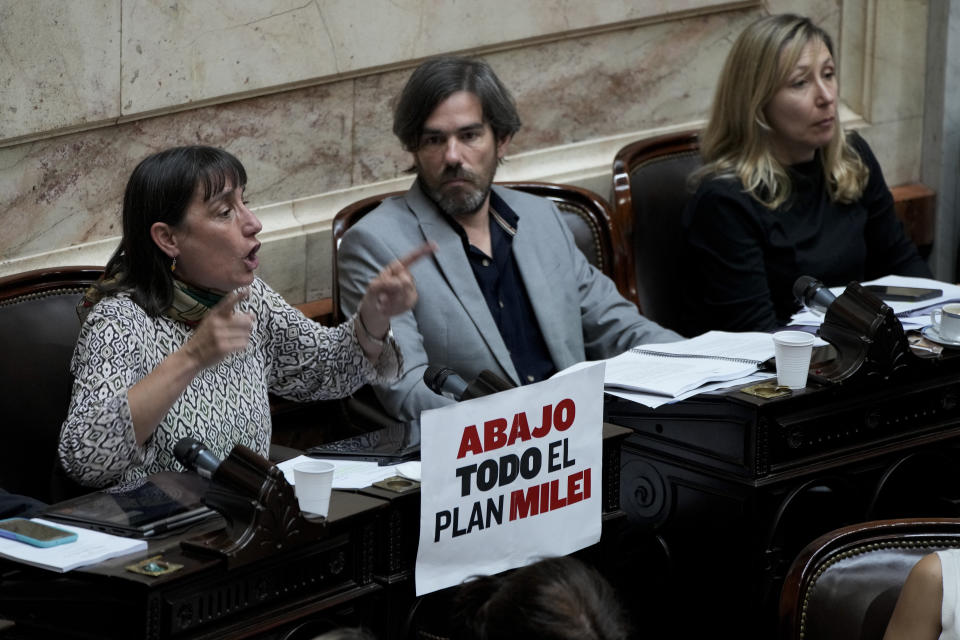 Opposition lawmaker Romina Del Plá speaks during the debate on a bill promoted by Argentine President Javier Milei that includes a broad range of economic, administrative, criminal, and environmental reforms, at Congress in Buenos Aires, Argentina, Tuesday, April 30, 2024. The sign reads in Spanish: "Down with all of Milei's plan." (AP Photo/Natacha Pisarenko)