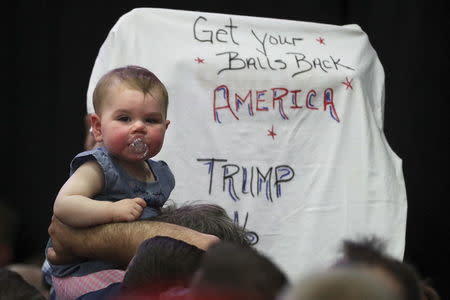 A baby is seen held up on shoulders before U.S. Republican presidential candidate Trump speaks at a campaign event at Grumman Studios in Bethpage, New York April 6, 2016. REUTERS/Carlo Allegri