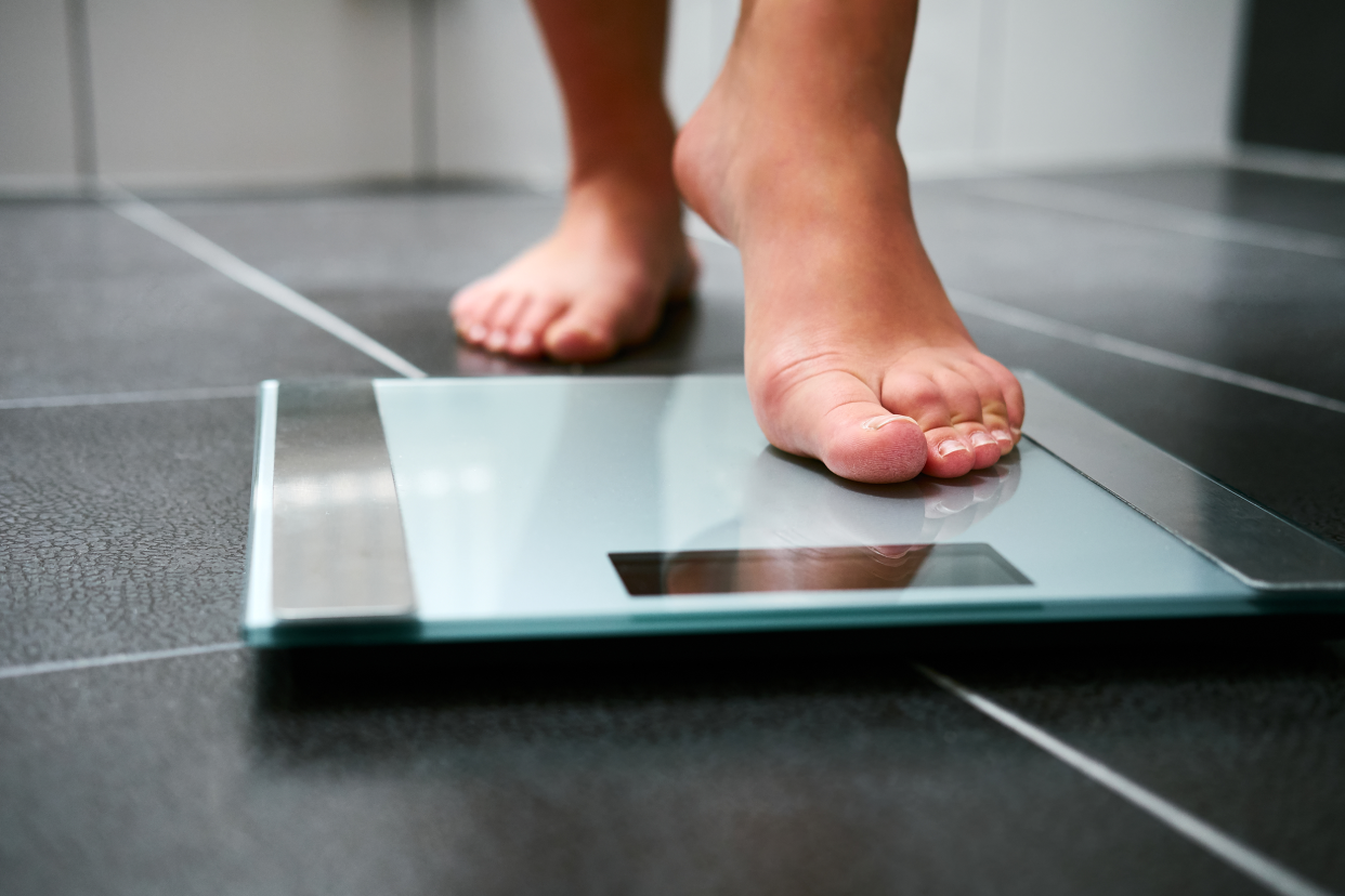 Woman's feet stepping onto a scale