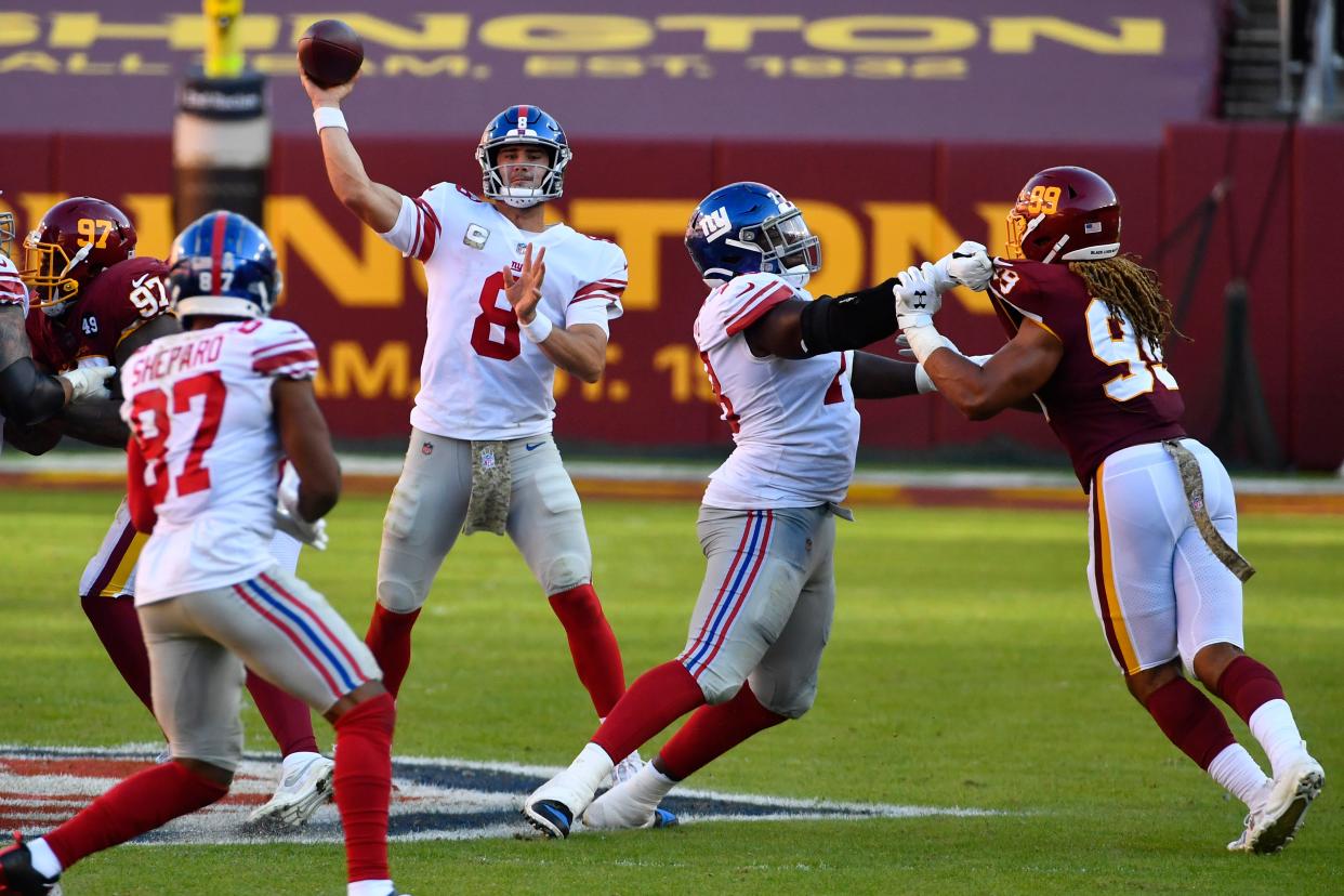 Nov 8, 2020; Landover, Maryland, USA;  New York Giants quarterback Daniel Jones (8) passes the ball to wide receiver Sterling Shepard (87) and left tackle Andrew Thomas (78) stands tall against Washington's Chase Young (99) during the third quarter at FedExField. Mandatory Credit: Brad Mills-USA TODAY Sports