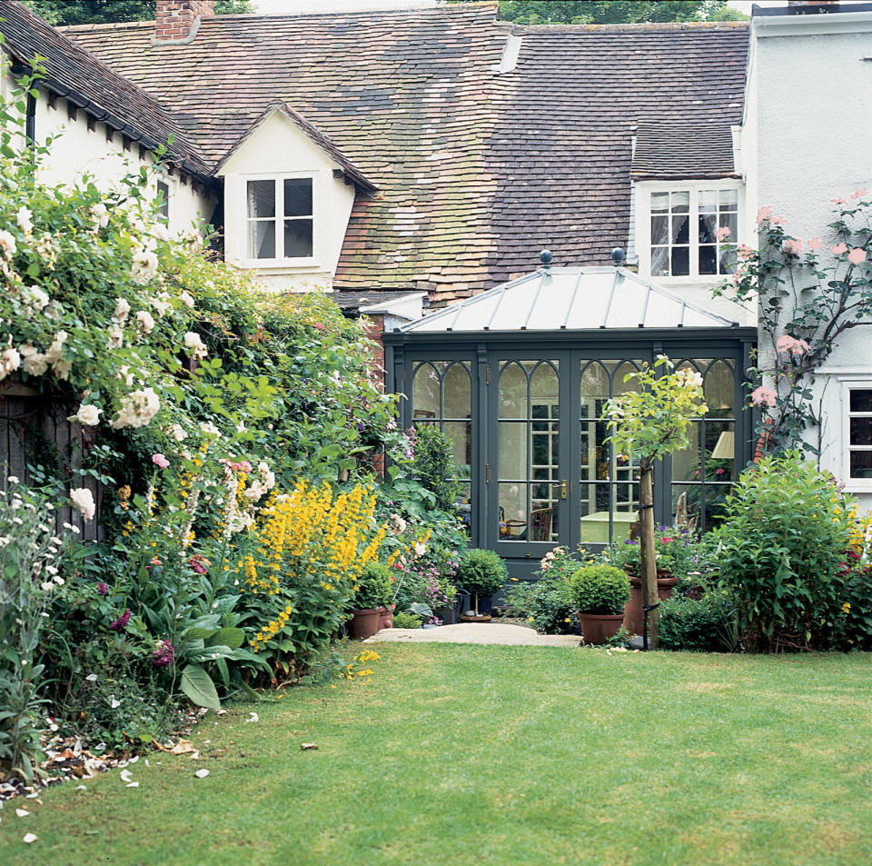 <p><span>Dark green paintwork helps this gothic design by Vale Garden Houses blend </span><span>with the garden</span></p>