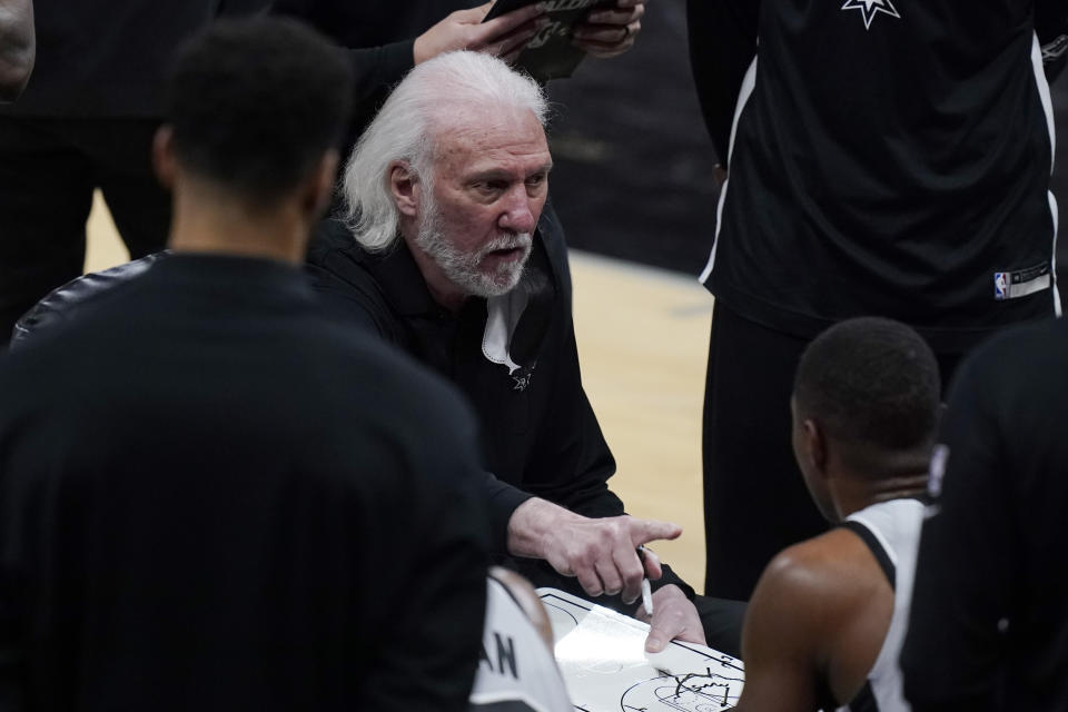 San Antonio Spurs head coach Gregg Popovich talks to his players during a timeout in the second half of an NBA basketball game against the Milwaukee Bucks in San Antonio, Monday, May 10, 2021. (AP Photo/Eric Gay)
