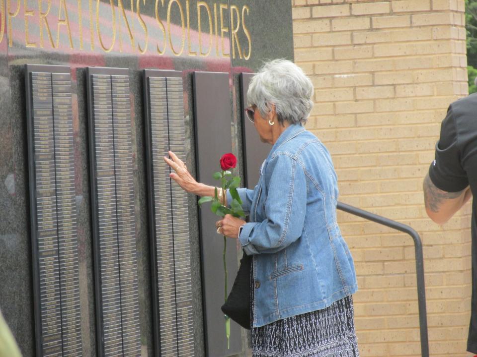 A Gold Star family prepares to touch the name of her loved one on the U.S. Army Special Operations Command Memorial Wall after a ceremony Thursday, May 25, 2023, at Fort Bragg.