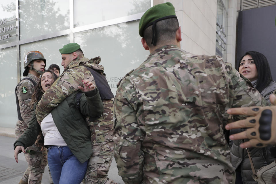 Lebanese army soldiers scuffle with anti-government protesters blocking a road leading to the parliament building in downtown Beirut, Lebanon, Monday, Jan. 27, 2020. Lebanese security forces scuffled Monday with protesters near the parliament building in downtown Beirut where lawmakers are scheduled to begin a two-day discussion and later approval of the budget amid a crippling financial crisis. (AP Photo/Hassan Ammar)