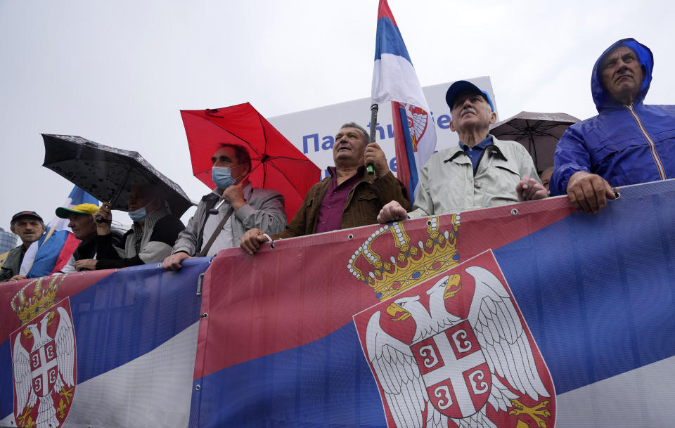 People hold Serbian flags in front of the Parliament building during the Serbia's President Aleksandar Vucic inauguration for a second term, in Belgrade, Serbia, Tuesday, May 31, 2022. Vucic was inaugurated Tuesday for his second term as Serbia's president, saying the Balkan country will remain on its European Union membership path and hinted that a new government might consider joining Western sanctions against ally Russia over the war in Ukraine. (AP Photo/Darko Vojinovic)