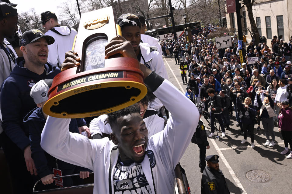 UConn's Adama Sanogo reacts as he holds the trophy during a parade to celebrate the team's NCAA college basketball championship, Saturday, April 8, 2023, in Hartford, Conn. (AP Photo/Jessica Hill)